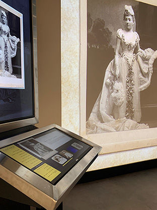Historic statue display with photograph, elegant dress, and exhibit detail within Allen County Public Library.