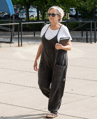 ACPL Patron walking across the library plaza on a sunny day