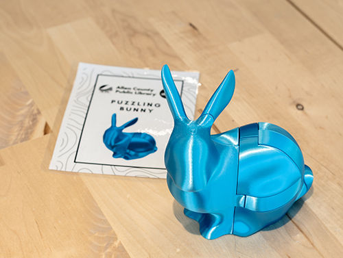 Blue interlocking rabbit puzzle displayed beside its assembly guide.