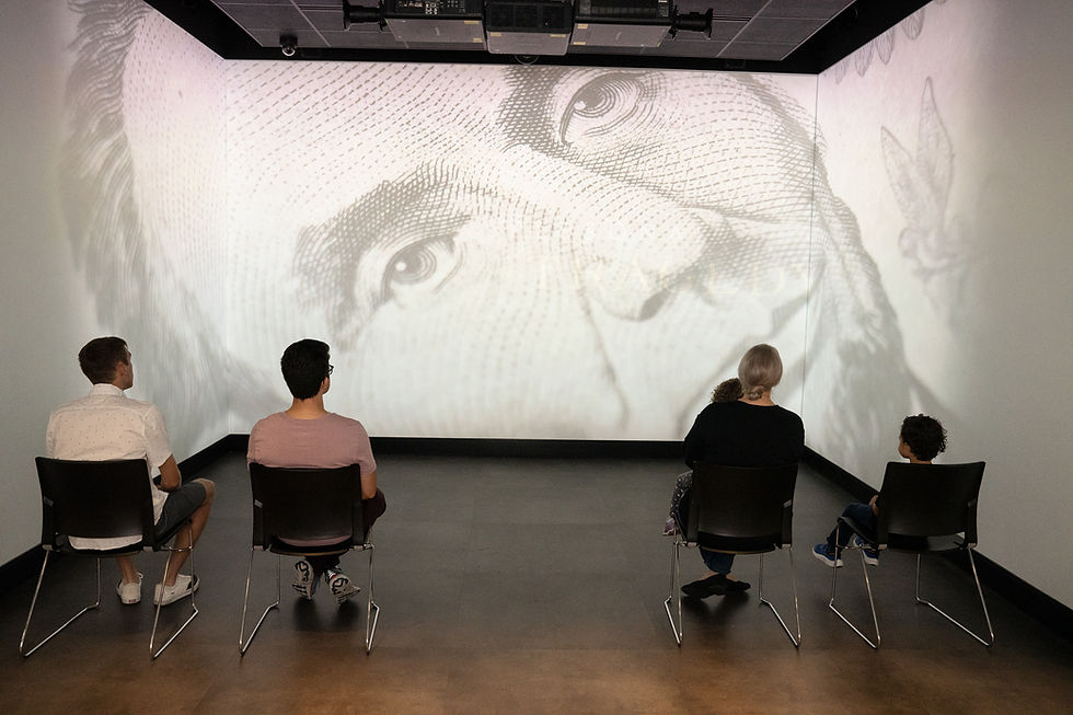 Four people view a large Lincoln portrait displayed in a gallery space.