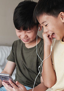 Asian-American children streaming a movie on a mobile device