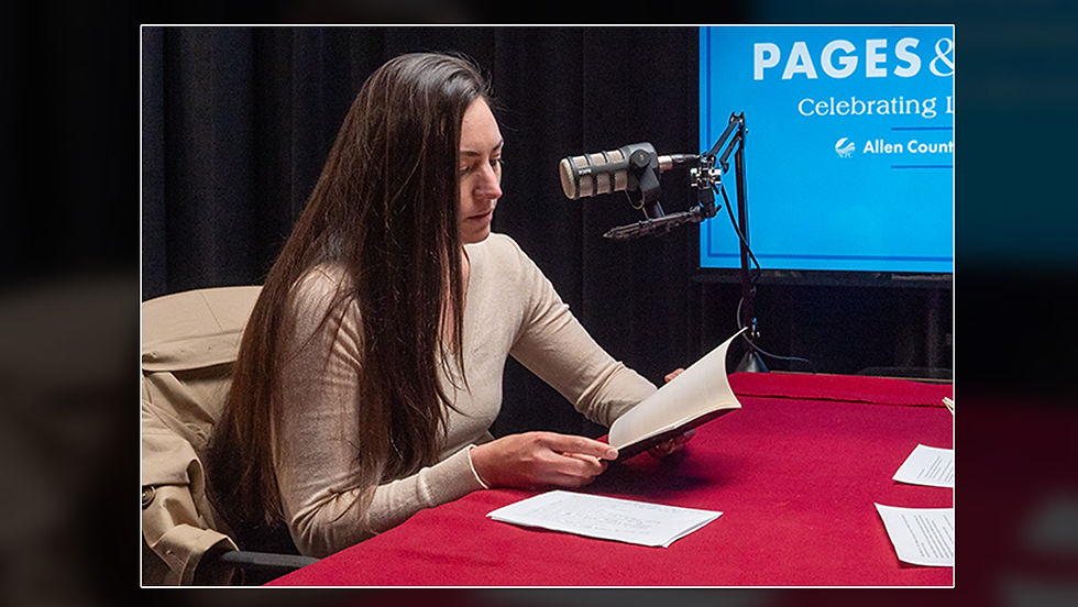 Meg Bell interviews local author Lauren Davis for the Pages & Voices podcast. Both sit at a table with microphones, reading from books and notes in a recording studio.