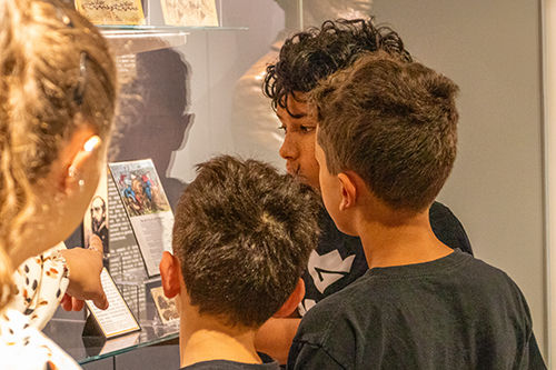 Niños observando una exposición de documentos históricos en la biblioteca pública del condado de Allen.
