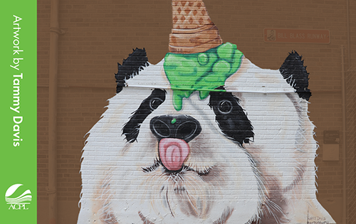 Mural-style illustration of a panda wearing an orange traffic cone and green splattered paint on its head.
