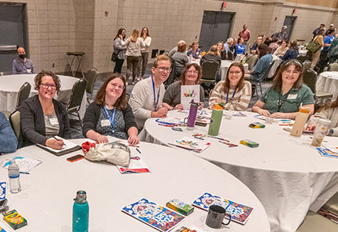 Un grupo de empleados de la biblioteca sentados en una mesa en el salón de eventos del Centro de Convenciones Grand Wayne.