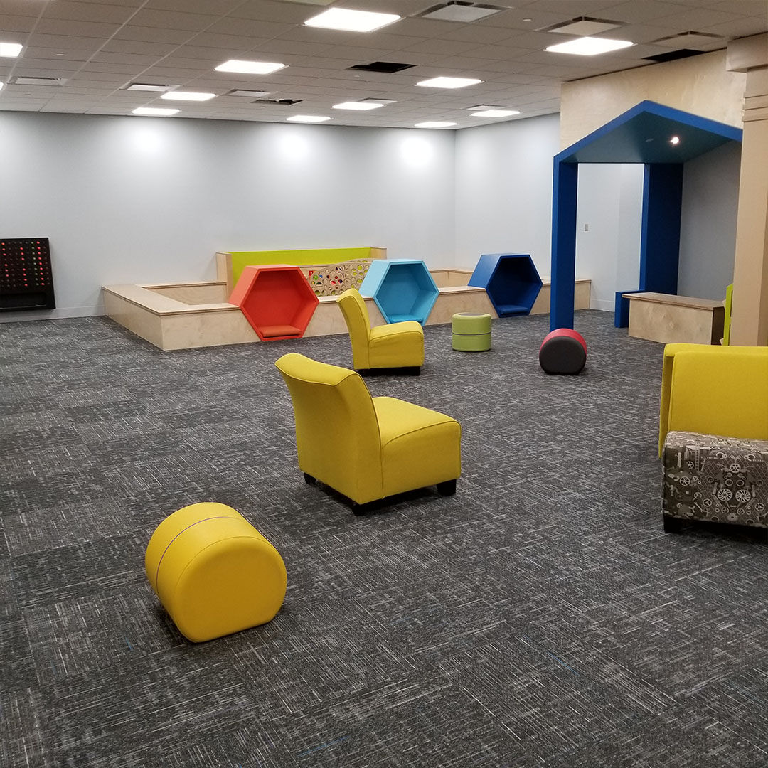 Bright, modern Storyscape area with colorful geometric seating and vibrant, comfortable chairs.